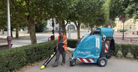 Agent de propreté urbaine utilisant un aspirateur urbain le glutton